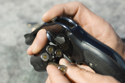Close up of man's hand reloading pistol chamber